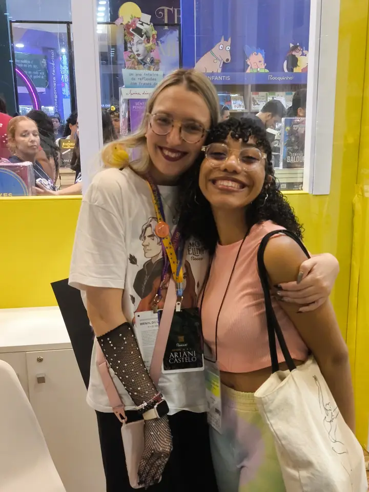 Júlia abraçada a uma leitora na Bienal do Rio 2025
